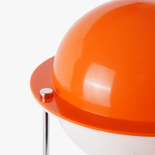 Astra sphere table lamp with solid orange globe shade floating on three slender metal legs