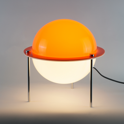 Astra sphere table lamp with solid orange globe shade floating on three slender metal legs