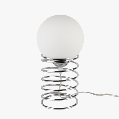 Lyra table lamp with frosted glass globe held by a coiled metal sculptural base