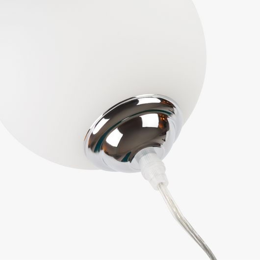Lyra table lamp with frosted glass globe held by a coiled metal sculptural base