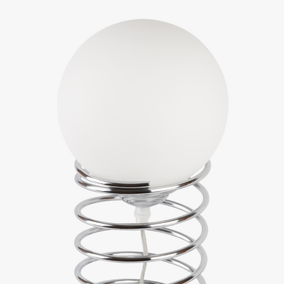 Lyra table lamp with frosted glass globe held by a coiled metal sculptural base