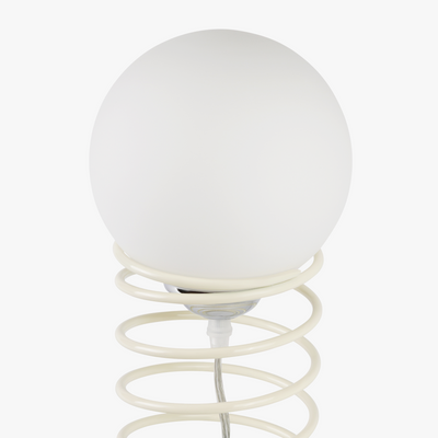 Lyra table lamp with frosted glass globe held by a coiled metal sculptural base